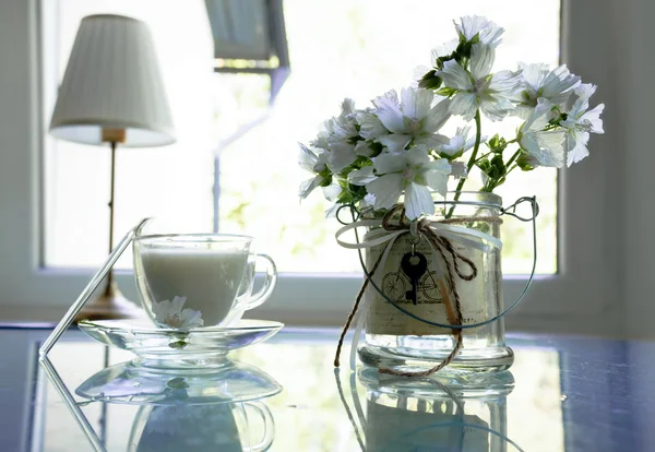 Summer Still Life with white bells, reading lamps, cup of the milk on a glass table — Stok Foto