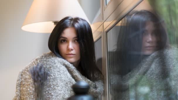 Beautiful girl sitting on a background of the rainy window. HD cinemagraph - motion photo seamless loop — Stock Video