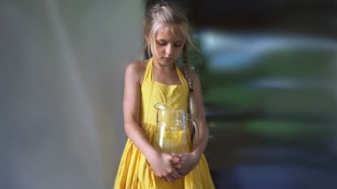 limonata elinde bir şişe ile sarı elbiseli kız. HD cinemagraph - hareket fotoğraf sorunsuz döngü