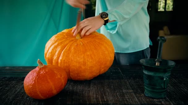 Женщина разрывает большие тыквы на Хэллоуин. подготовка к празднику — стоковое видео