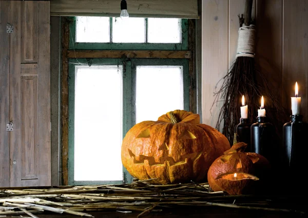 Halloween. Vintage interior in western style. candles, antique clock and glowing pumpkins on the background of window — Stock Photo, Image