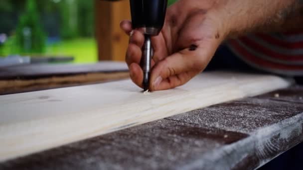 Carpinteiro broca para perfurar furos na placa. mãos fechadas — Vídeo de Stock