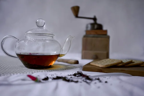Τρόπος ζωής. τσαγιέρα με ισχυρό τσάι, χειροκίνητο μύλο και φρέσκο κράκερ στο τραπέζι — Φωτογραφία Αρχείου