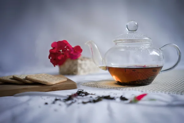 Τρόπος ζωής. τσαγιέρα με ισχυρό τσάι και φρέσκα κράκερ στο τραπέζι — Φωτογραφία Αρχείου