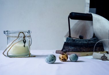 Natürmort. Masada Vintage nesneler: eski dökme demir, keten peçeteler, süt, bir kavanoz rulo, Bıldırcın yumurta