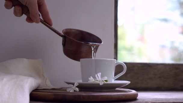 Rustikales Stillleben. Frauenhand gießt heißes Wasser aus einem Kupfereimer in die Tasse — Stockvideo