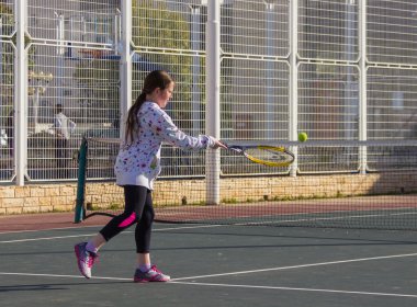 Sahada Tenis oynayan kız ve raket topa vurur