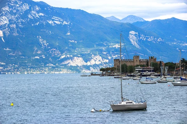Båten på bakgrund av fästningen och bergen i Gardasjön, Italien — Stockfoto