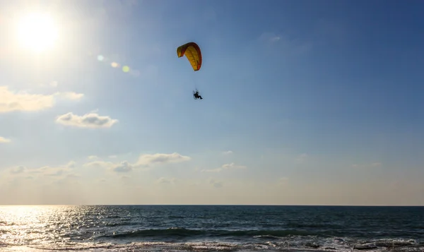 Pára-quedas em paraquedas motorizados voando sobre o mar ao pôr-do-sol — Fotografia de Stock