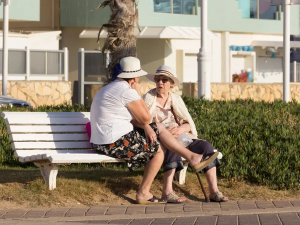 Dos ancianas sentadas en un banco y hablando en el paseo marítimo — Foto de Stock
