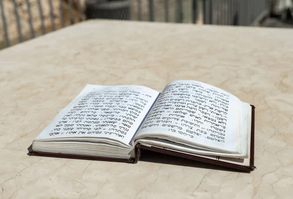 İbranice dua metninin bulunduğu açık kutsal Yahudi kitabı, Tehelim, eski şehrin Batı Duvarı yakınında bir masada yatmaktadır. İsrail 'deki Kudüs' ün