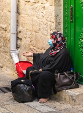 Kudüs, İsrail, 24 Ekim 2020: Beit HaBad caddesinde oturan ve İsrail 'in eski Kudüs kentinin Müslüman kesiminde sadaka dilenen yaşlı Arap kadın