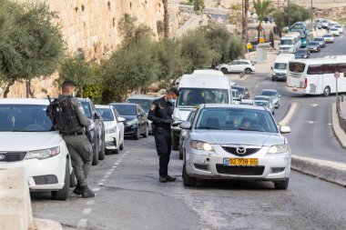 Kudüs, İsrail, 14 Kasım 2020: İsrailli polis, İsrail 'in eski Kudüs kentindeki Gübre Kapısı yakınlarındaki özel bir arabanın sürücüsünün belgelerini kontrol ediyor.