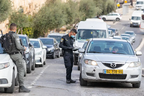 Kudüs, İsrail, 14 Kasım 2020: İsrailli polis, İsrail 'in eski Kudüs kentindeki Gübre Kapısı yakınlarındaki özel bir arabanın sürücüsünün belgelerini kontrol ediyor.
