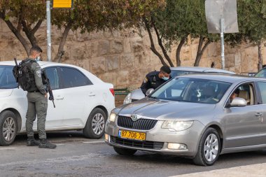 Kudüs, İsrail, 14 Kasım 2020: İsrailli polis, İsrail 'in eski Kudüs kentindeki Gübre Kapısı yakınlarındaki özel bir arabanın sürücüsünün belgelerini kontrol ediyor.