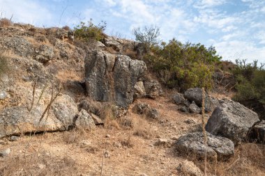 İsrail 'in kuzeyindeki Celile' de, hızlı, sığ, soğuk bir dağ olan Ayun nehrinin yukarısındaki yamaçtaki büyük kayalar.