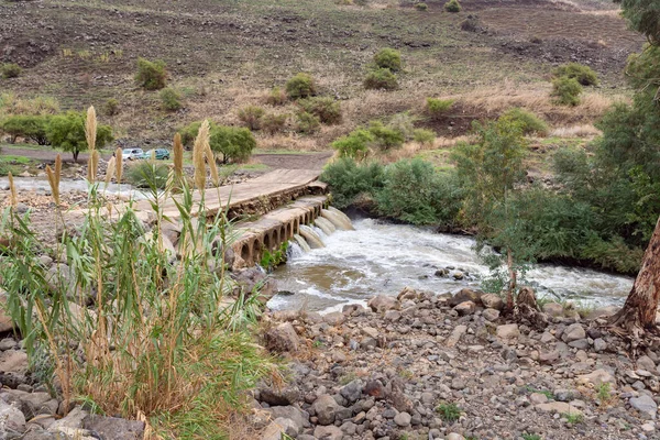A country road passes through a concrete bridge with pipes for water passage over the Jordan River in the Golan Heights in northern Israel — Stock Image Country Road Passes Concrete Bridge Pipes Water Passage Jordan River Royalty Free Stock Images