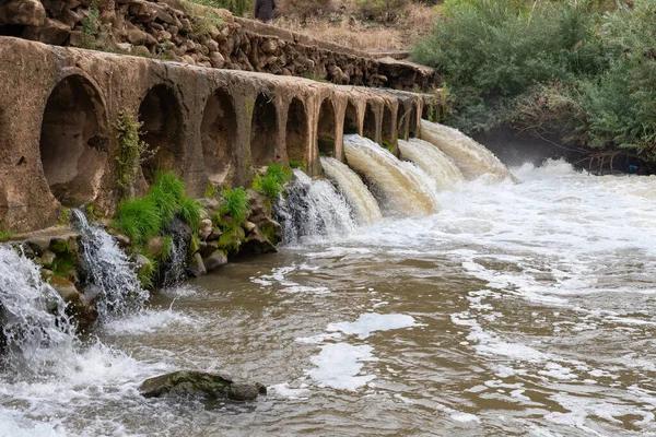 The concrete bridge over the Jordan River made for a road across with pipes for water passage in the Golan Heights in northern Israel — Stock Image Concrete Bridge Jordan River Made Road Pipes Water Passage Golan Stock Picture