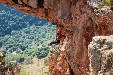 Shlomi, İsrail, 19 Aralık 2020: İki sporcu, dağdan Kuzey İsrail 'deki Keshet Mağarası' na halatla iniyor - tırmanıyor - ip kopuyor -.