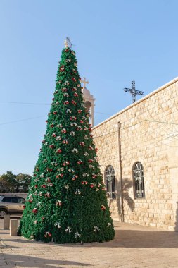 İsrail 'in kuzeyindeki Hayfa şehrindeki Melkite Katolik Kilisesi' nin Aziz Elias Katedrali 'nin avlusunda süslenmiş Noel ağacı.