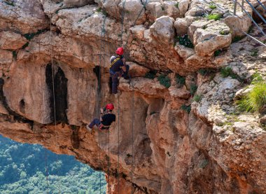 Shlomi, İsrail, 19 Aralık 2020: İki sporcu, dağdan Kuzey İsrail 'deki Keshet Mağarası' na halatla iniyor - tırmanıyor - ip kopuyor -.