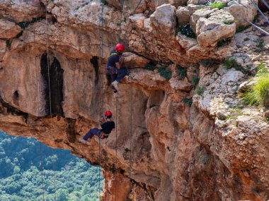 Shlomi, İsrail, 19 Aralık 2020: İki sporcu, dağdan Kuzey İsrail 'deki Keshet Mağarası' na halatla iniyor - tırmanıyor - ip kopuyor -.