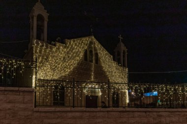 Melkite Katolik Kilisesi 'nin Aziz Elias Katedrali' nin avlusunun gece manzarası. İsrail 'in kuzeyindeki Hayfa şehrinde Noel kutlaması için dekore edilmiş.