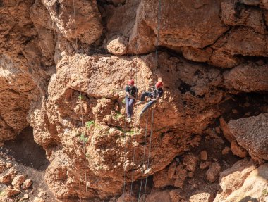 Shlomi, İsrail, 19 Aralık 2020: İki sporcu, dağdan Kuzey İsrail 'deki Keshet Mağarası' na halatla iniyor - tırmanıyor - ip kopuyor -.