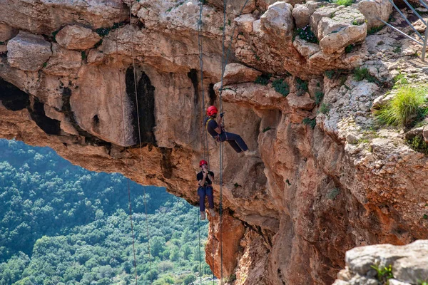Shlomi, İsrail, 19 Aralık 2020: İki sporcu, dağdan Kuzey İsrail 'deki Keshet Mağarası' na halatla iniyor - tırmanıyor - ip kopuyor -.