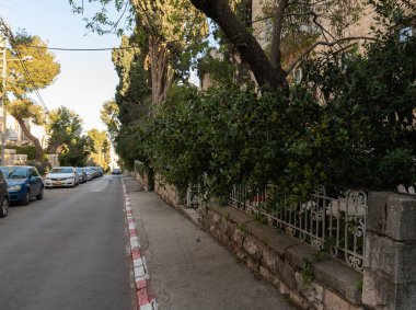 Kudüs, İsrail, 27 Şubat 2021: Eski Kudüs bölgesi Talbia 'daki sessiz, yeşil Hovevei Tsiyon Caddesi' nin akşam manzarası - Kudüs, İsrail 'deki Komiyum