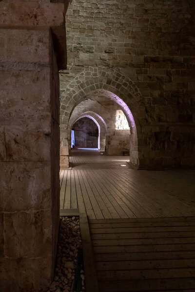 Passage between stone halls of the Crusader fortress of the old city of Acre in northern Israel