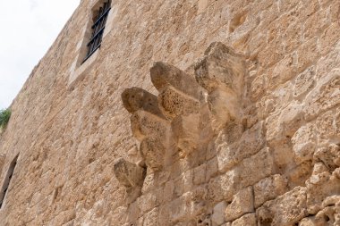Eski İsrail 'in kuzeyindeki Acre şehrinde ortaçağ tarzında balkon için korunmuş bir tabanı olan eski bir taş binanın duvarı.