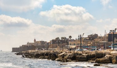 Acre, İsrail, 26 Haziran 2021: Tekneden Akdeniz 'e, kale duvarına ve İsrail' in kuzeyindeki eski Acre kentindeki binalara bakın