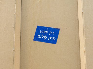 Üzerinde İbranice yazılar olan mavi etiket, İsrail 'in Kudüs kentindeki Jaffa Kapısı' nın yakınındaki metal bir çite sadece İsa huzur verir.