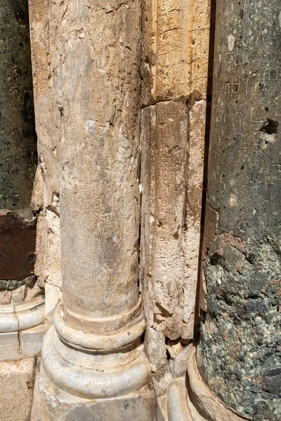 Notes for the Almighty nested between the stone columns at the entrance to the Church of the Holy Sepulcher in Christian quarters in the old city of Jerusalem, Israel