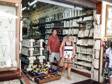 Rhodes, Greece, July 06, 2011 : Tourists browse a souvenir shop at a local market in Rhodes city on Rhodes island in Greece