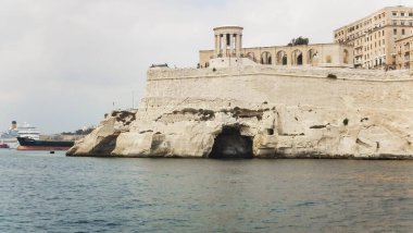 Valletta, Malta, 05 Temmuz 2013: Malta 'daki Valletta kentinde şehir savunma kalesi duvarları ve Kuşatma Çanı Savaşı Anıtı' nın turistik teknesinden görüntüler