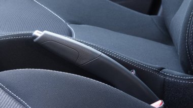    Ön koltuklar arasında modern el freni kolu ve vites kutusu.                            