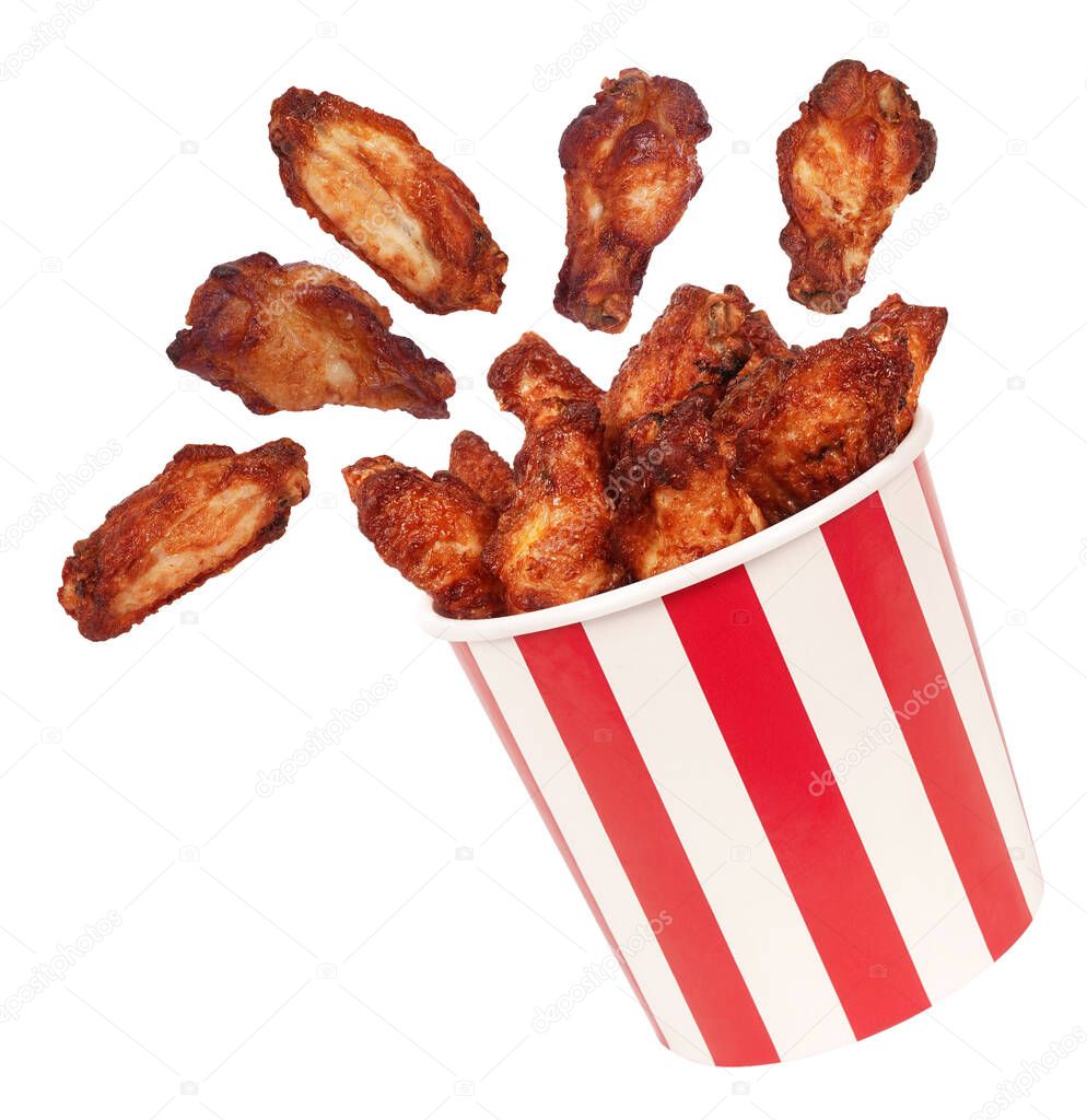 Perfect chicken wings flying around from big red white stripes bucket box                               