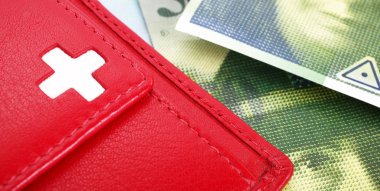 İsviçre bayrağı ile İsviçre Frankı banknot ve kırmızı cüzdan
