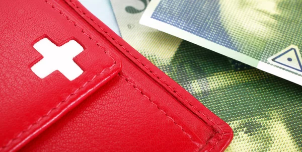 Swiss francs banknotes and red wallet with Swiss flag