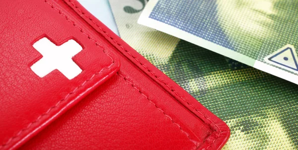 İsviçre bayrağı ile İsviçre Frankı banknot ve kırmızı cüzdan