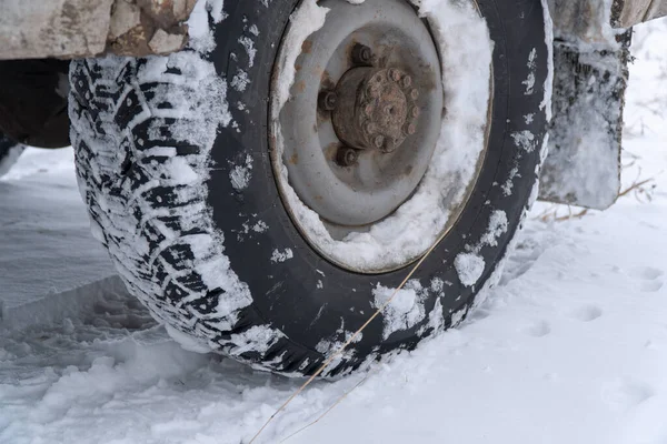 Studded winter car tires on an old car on snowy road — Stock Image Studded winter car tires on an old car on snowy road Royalty Free Stock Images