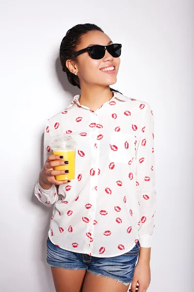 Mooi jong meisje poseren in de studio op een witte achtergrond. het drinken van sinaasappelsap — Stockfoto