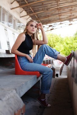 Kolan hipster stadyumda poz.