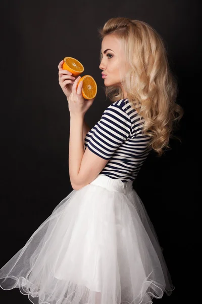 Vacker blondin i studion med apelsiner — Stockfoto
