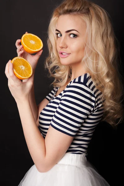 Belle blonde en studio avec des oranges — Photo