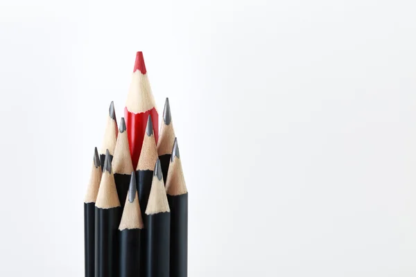 Black pencils with a red one in the middle — Stock Photo, Image