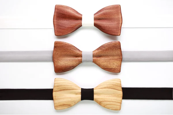 Three wooden bow ties with white, grey and black ribbons. Flat lay, isolated. Team work, career, wedding, eco concept. — Stock Photo, Image