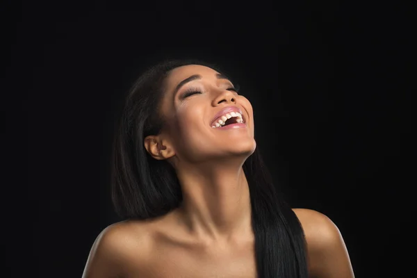 Rindo nua bonita afro-americana com bom senso de humor sorrindo enquanto inclina a cabeça para trás para olhar para o ar. Mulato menina cabelo longo . — Fotografia de Stock